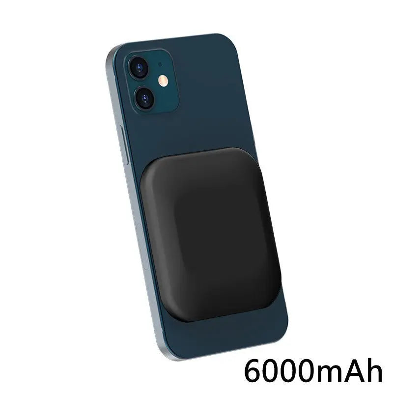 Black magnetic wireless power bank attached to blue iPhone back showing 6000mAh capacity text