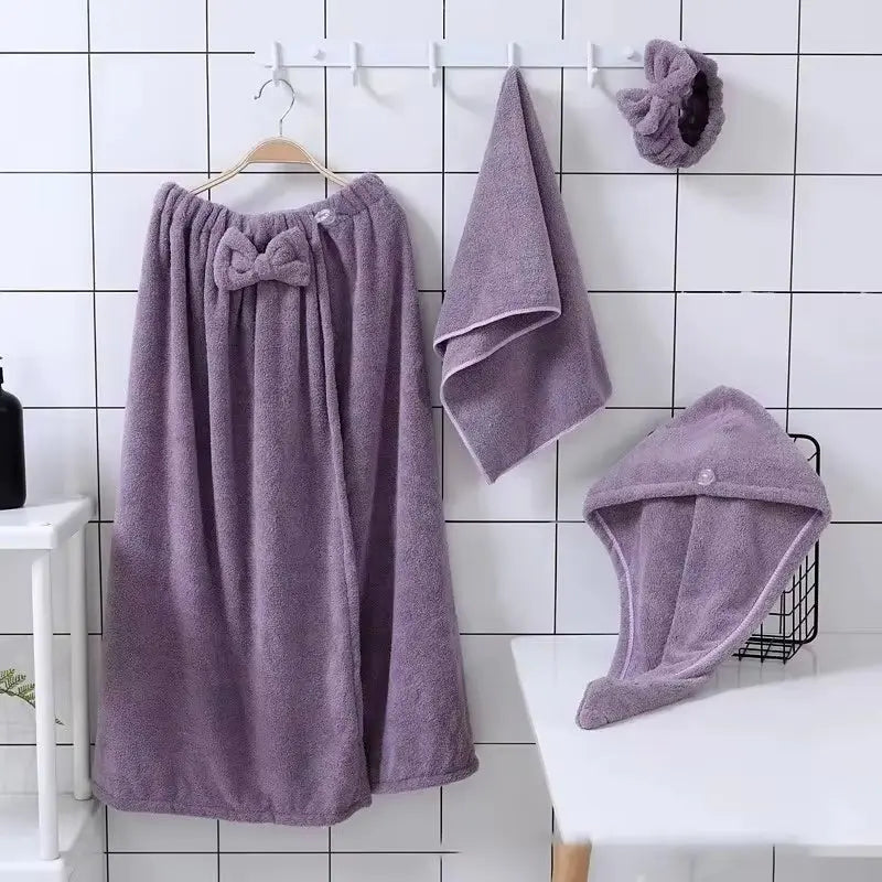 Purple microfiber bath towel set for women including wrap skirt, face towel, hair towel, and hairband on hooks and table
