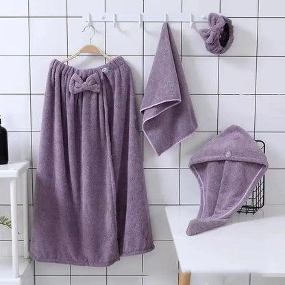 Purple microfiber bath towel set for women including wrap skirt, face towel, hair towel, and hairband on hooks and table