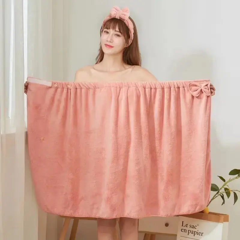 Woman holding large pink microfiber bath towel with elastic top and decorative bow detail