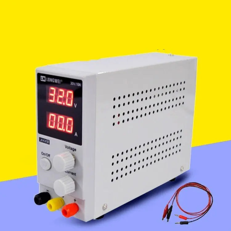 Compact white adjustable DC power supply with digital voltage and current display and cable set against yellow and blue background