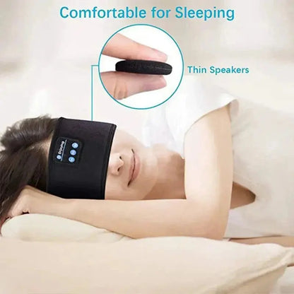 Woman wearing black Bluetooth sleep headband with thin built-in speakers lying on pillow with eyes closed