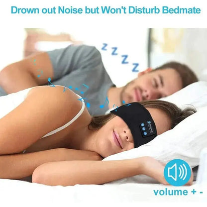 Woman wearing black Bluetooth sleep headband with built-in speakers lying beside sleeping man in bed