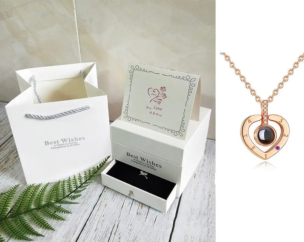 Rose gold heart pendant necklace with black center stone and gift box set with "Best Wishes" card and shopping bag