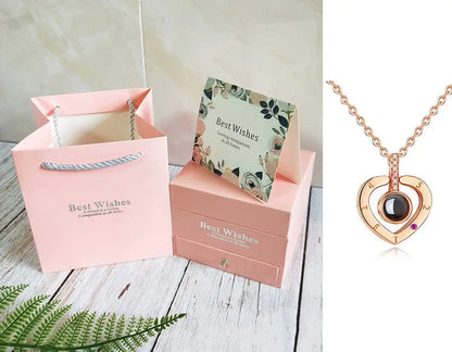 Gift set with pink Best Wishes bag, matching box, floral card, and rose gold heart-shaped necklace with black stone