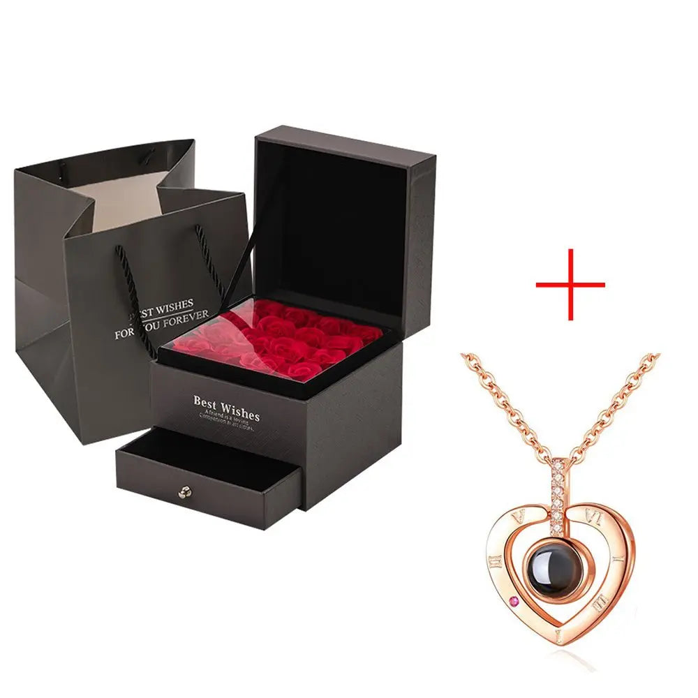 Black gift box with red roses and drawer paired with rose gold heart-shaped pendant necklace with black stone