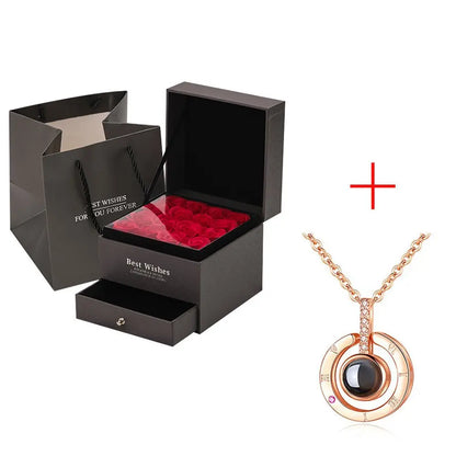 Black gift box with preserved red roses, matching drawer and rose gold circular pendant necklace with gemstone centerpiece