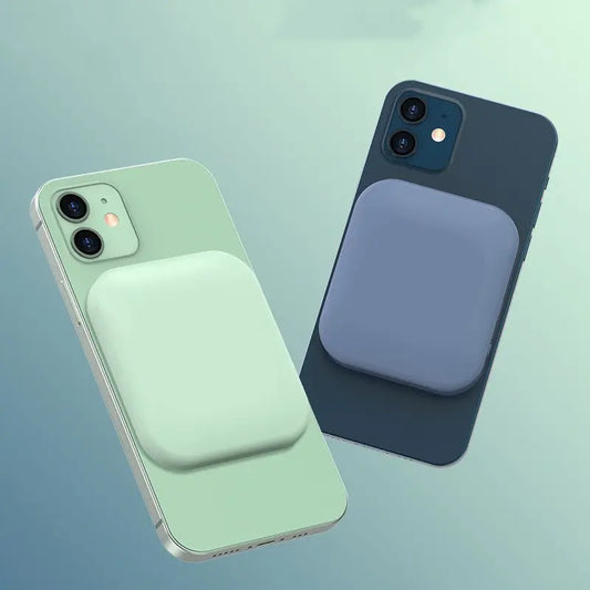 Two iPhones in green and blue with compatible MagSafe magnetic wireless charging power banks attached on the back