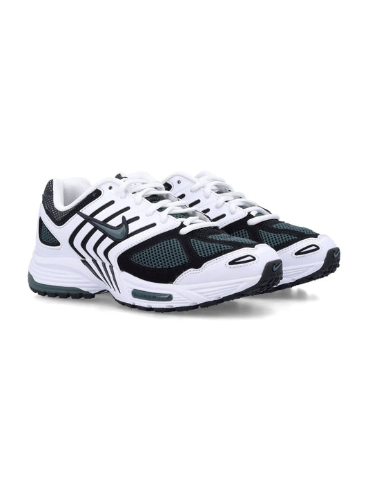 White and black Nike women's sneakers with green mesh accents and rubber sole designed for running and casual wear