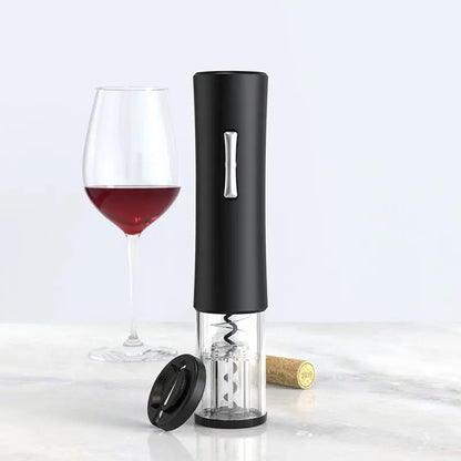 Black Qier USB rechargeable electronic wine bottle opener with clear base and silver button beside wine glass and cork