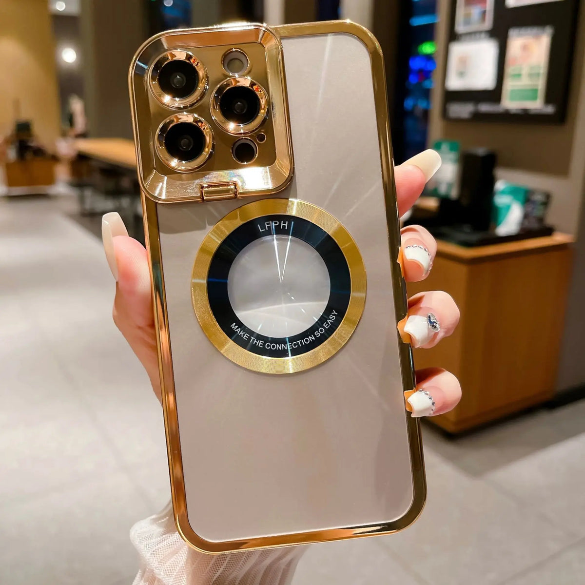 Hand holding gold electroplated iPhone case with CD pattern and magnetic suction ring for iPhone 12 13 14 Pro Max