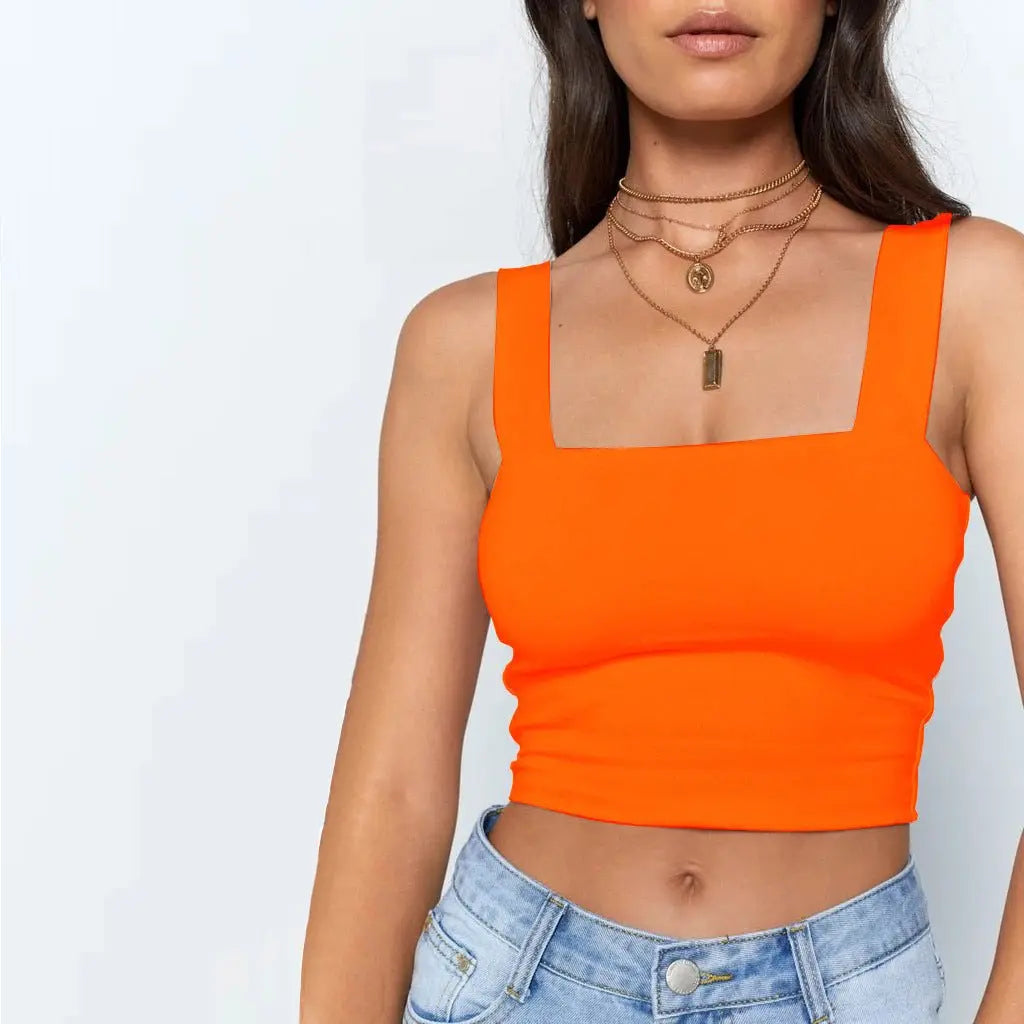 Front view of sleeveless bright orange fashion crop top with square neckline paired with light blue denim jeans