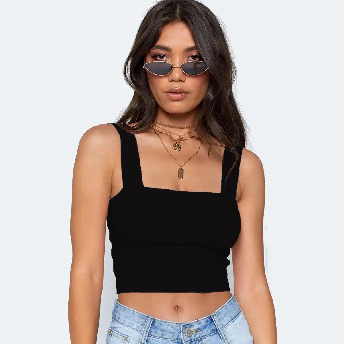 Front view of woman wearing black sleeveless fashion crop top with square neckline and light wash denim jeans