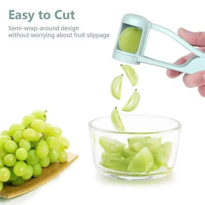 Light blue grape slicer cutting green grape into quarters over glass bowl with bunch of grapes nearby