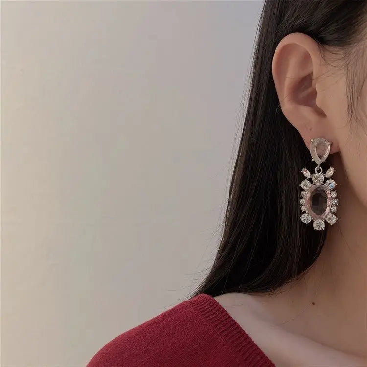 Close-up of Hot Girl H Lala Diamond personalized geometric silver earrings worn by woman with long dark hair and red top