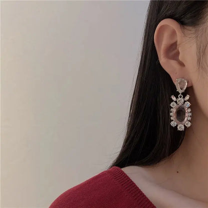 Close-up of Hot Girl H Lala Diamond personalized geometric silver earrings worn by woman with long dark hair and red top