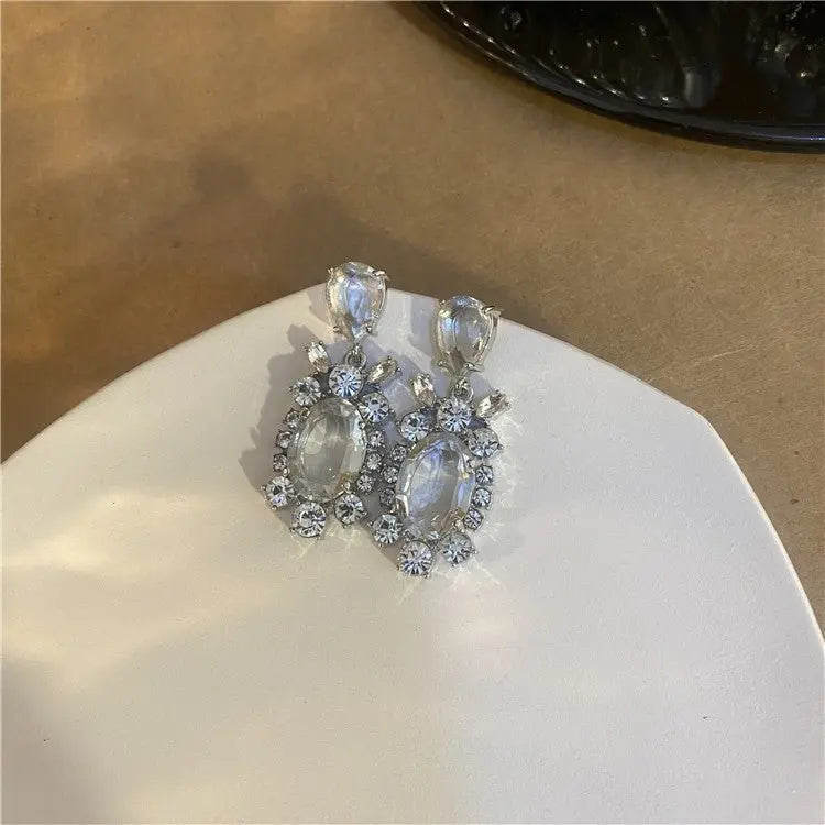 Close-up of Hot Girl H Lala Diamond personalized earrings featuring clear stones and geometric silver metal design