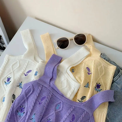 Three Hyuna style knit crop tops in apricot, white, and purple with floral embroidery and thick shoulder straps