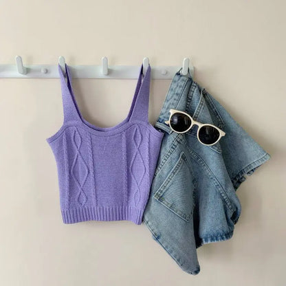 Lilac knitted Hyuna style crop top with cable pattern hanging next to folded blue denim shorts and white round sunglasses