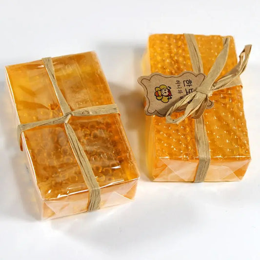 Two transparent Korean propolis honey soaps with textured surface, tied with natural fiber ribbons and brown tags