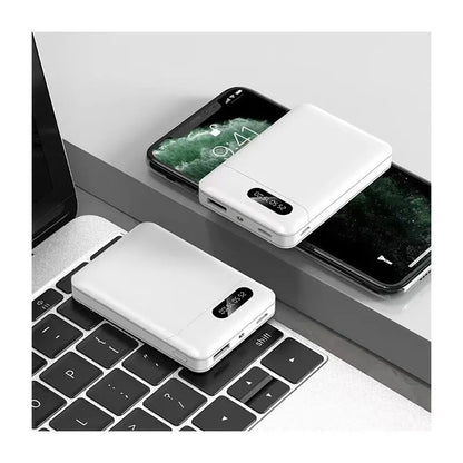 White large capacity portable mobile power bank with digital display placed on laptop and smartphone surface