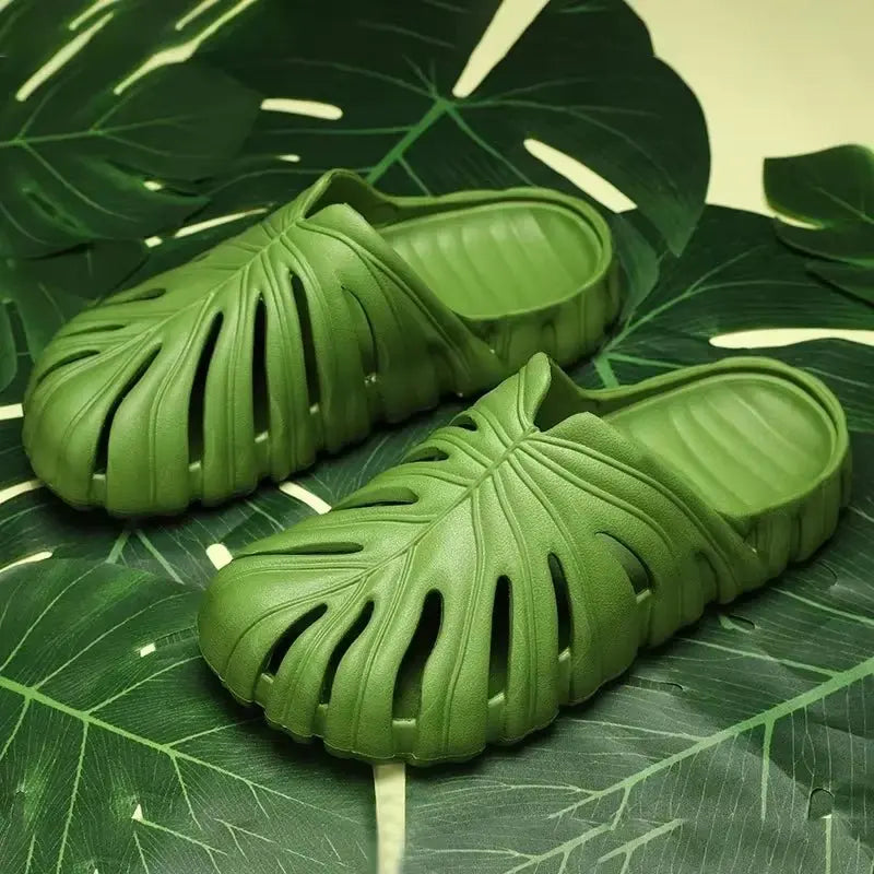 Pair of green male platform slippers with cloud-like sole and cut-out monstera leaf design on textured footbed
