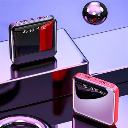 Two mini power banks with digital display and glossy mirror finish in purple and red colors on reflective surface