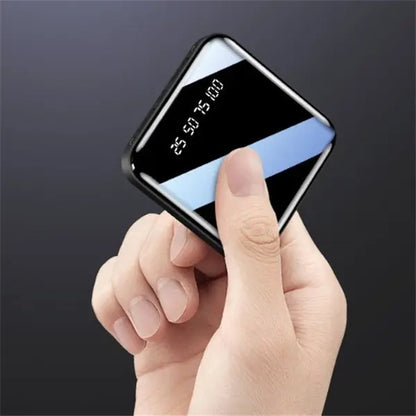 Hand holding Mini Power Bank 20000 mAh portable charger with sleek mirror finish and digital battery display