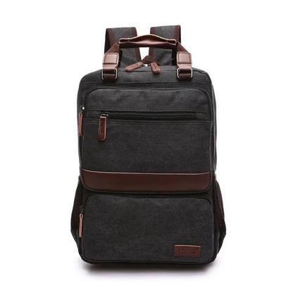 Front view of black canvas laptop backpack with brown leather accents and multiple zippered compartments
