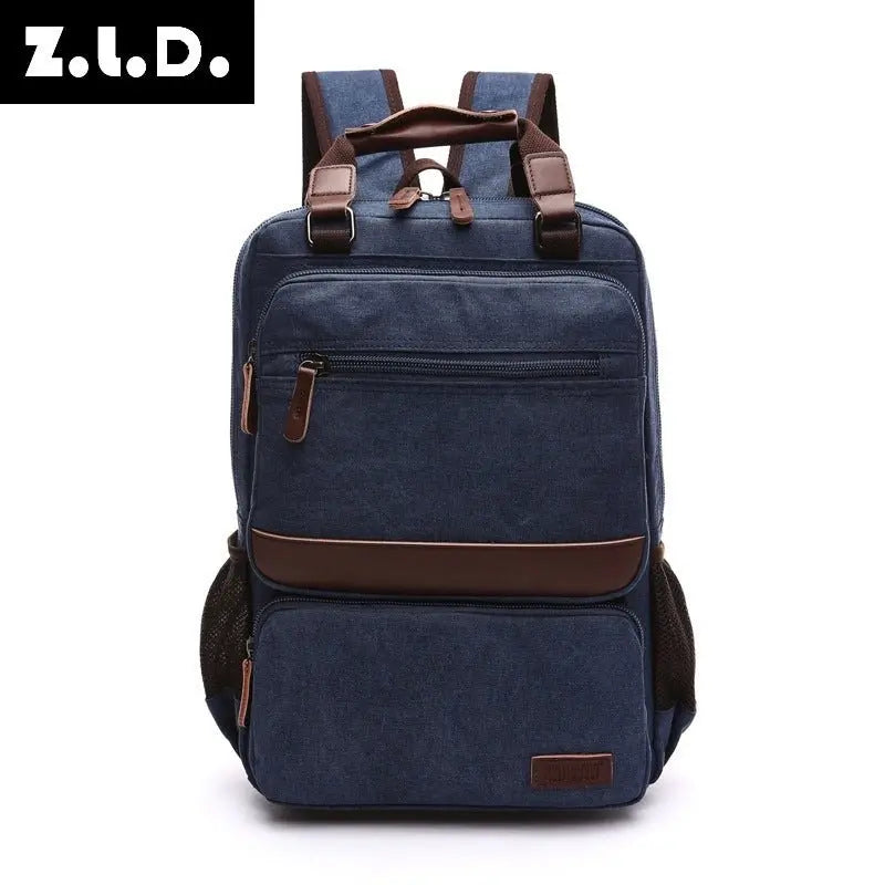 Front view of navy blue canvas laptop backpack with brown leather accents and multiple zippered compartments