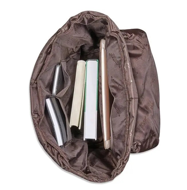 Top view of brown linen oxford cloth men's backpack interior showing multiple compartments with books and tablet inside