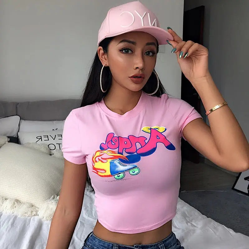 Front view of slim fit pink short sleeve crop top with colorful roller skate print and round neck collar