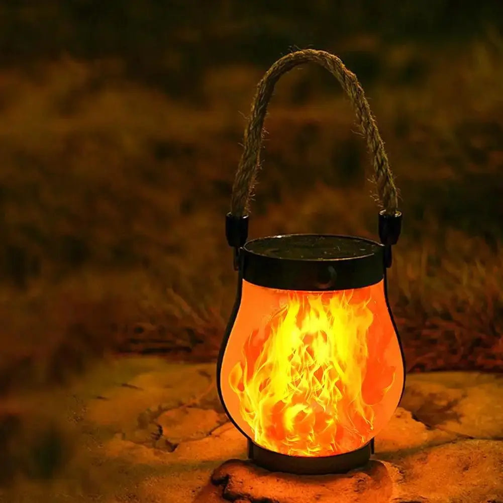 Solar Flame Lamp hanging garden lantern with rechargeable flame effect and hemp rope handle outdoors at night