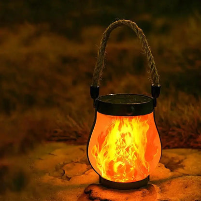 Solar Flame Lamp hanging garden lantern with rechargeable flame effect and hemp rope handle outdoors at night