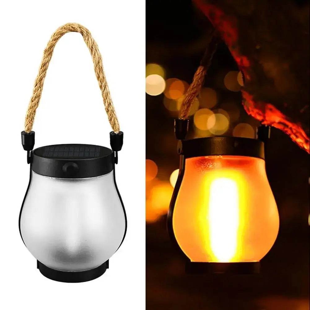 Solar Flame rechargeable hanging garden lantern with hemp rope handle shown unlit and glowing outdoors at night