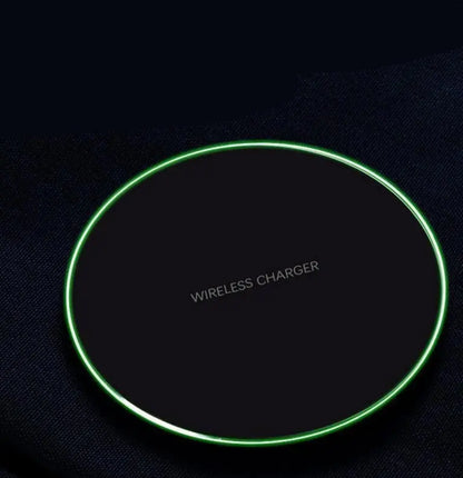 Black round wireless charger pad with glowing green edge and "WIRELESS CHARGER" text in center on dark surface
